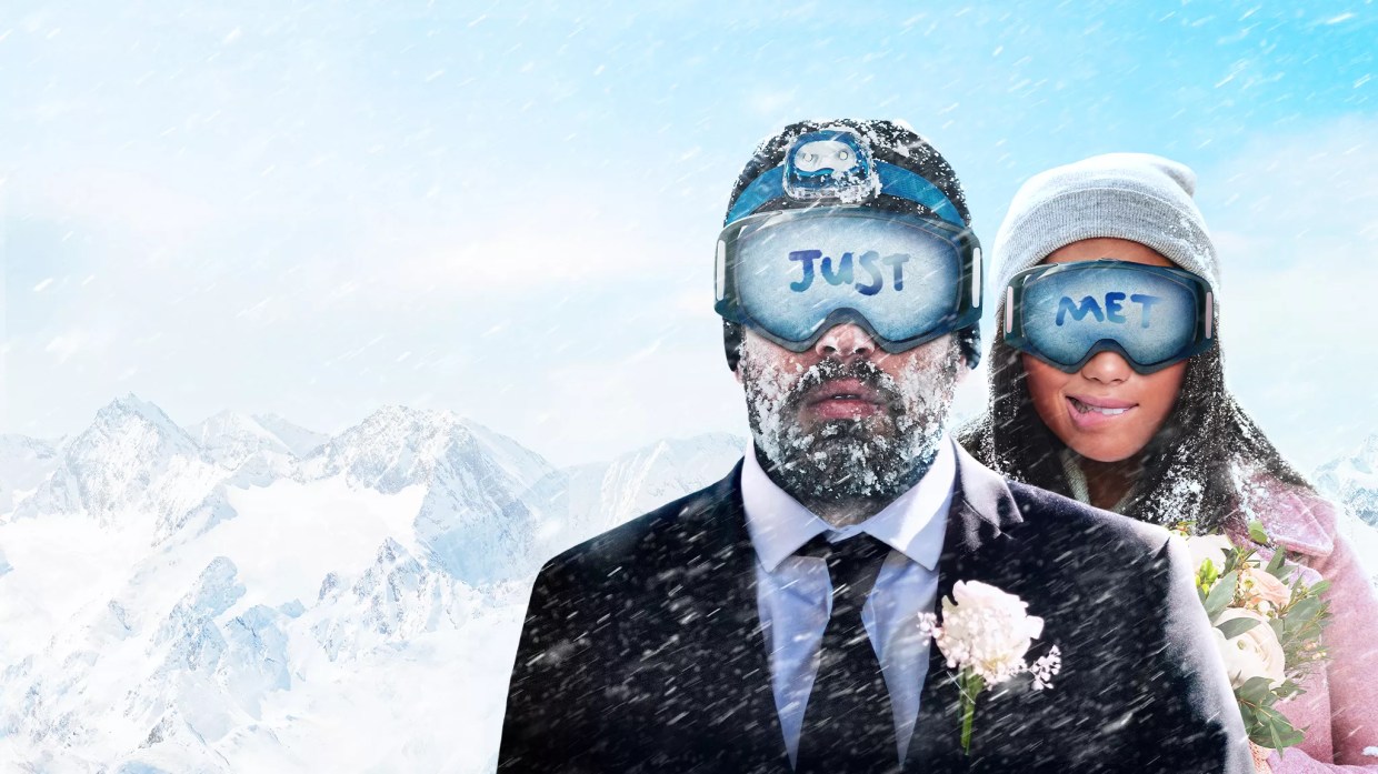 bride and groom in snow and goggles.