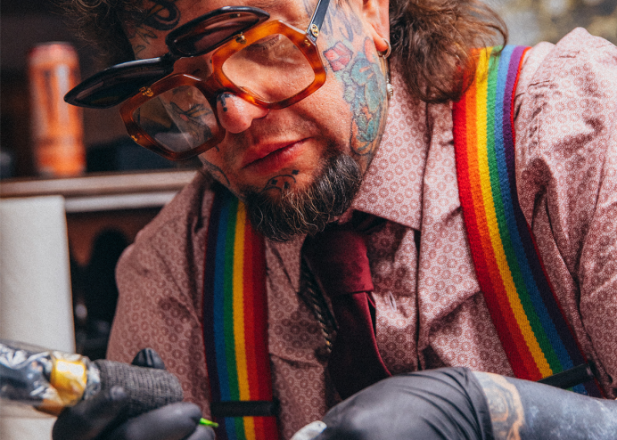 man with tattoos and rainbow suspenders wearing flipshade sunglasses