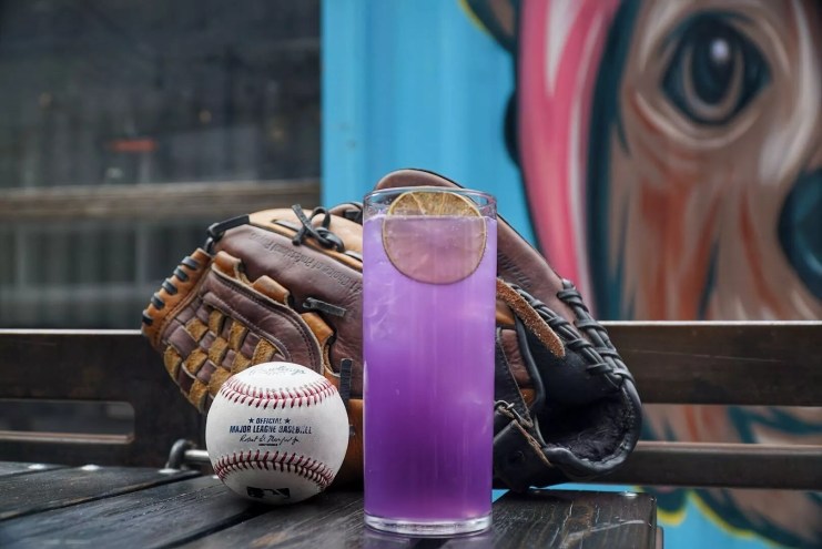 a purple cocktail in front of a baseball glove