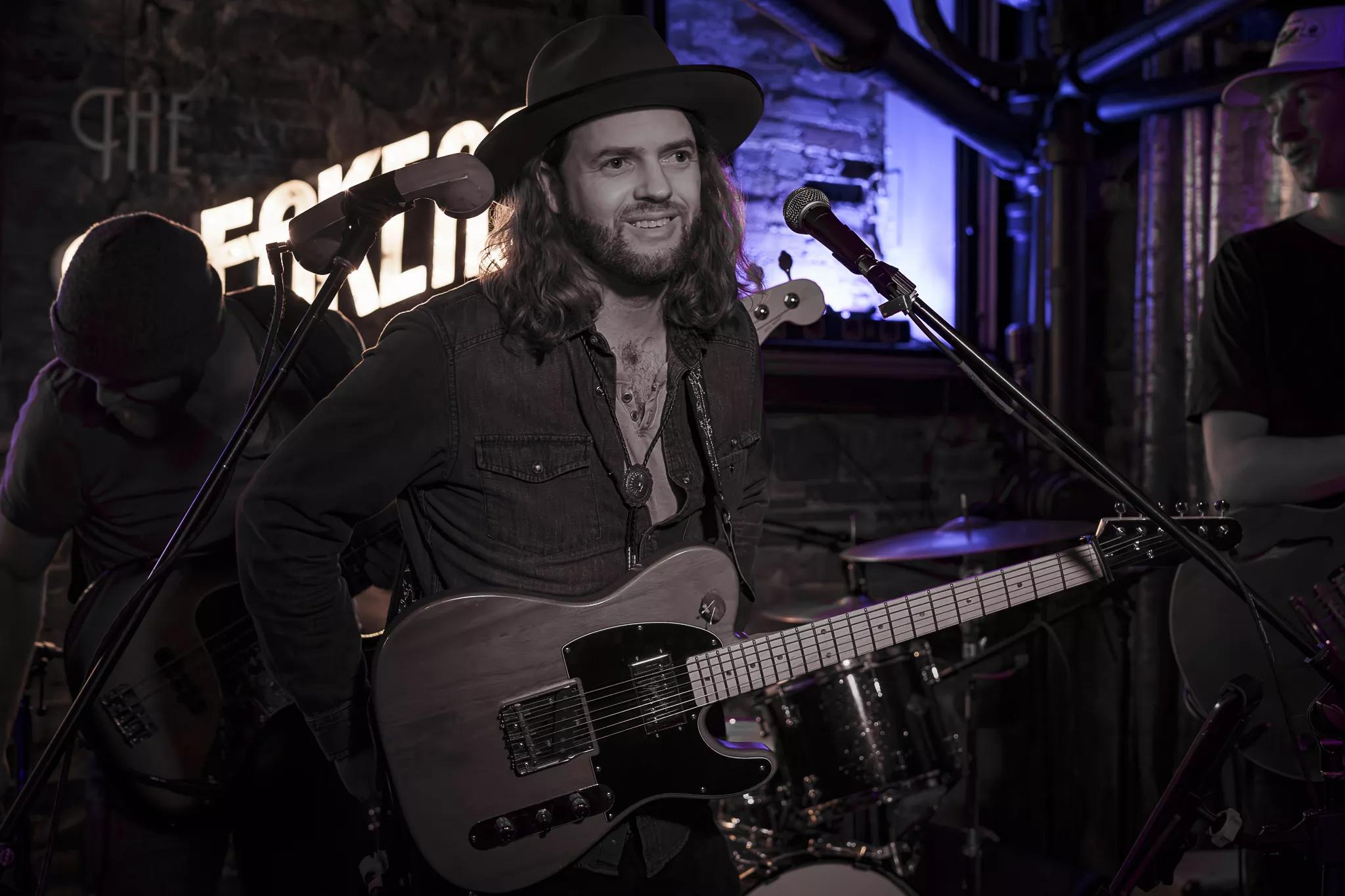man in a hat playing guitar