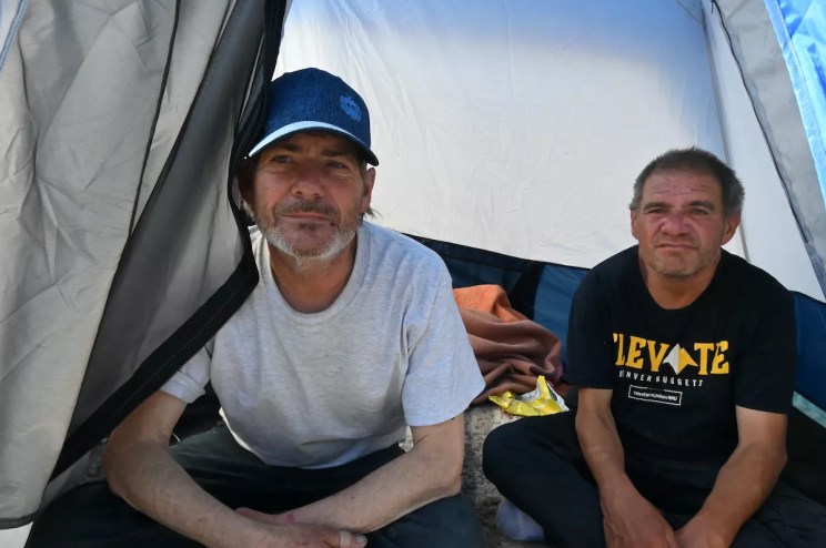 Two homeless residents sit in their tent in Denver.