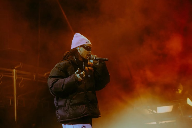 man in pink beanie rapping at a microphone
