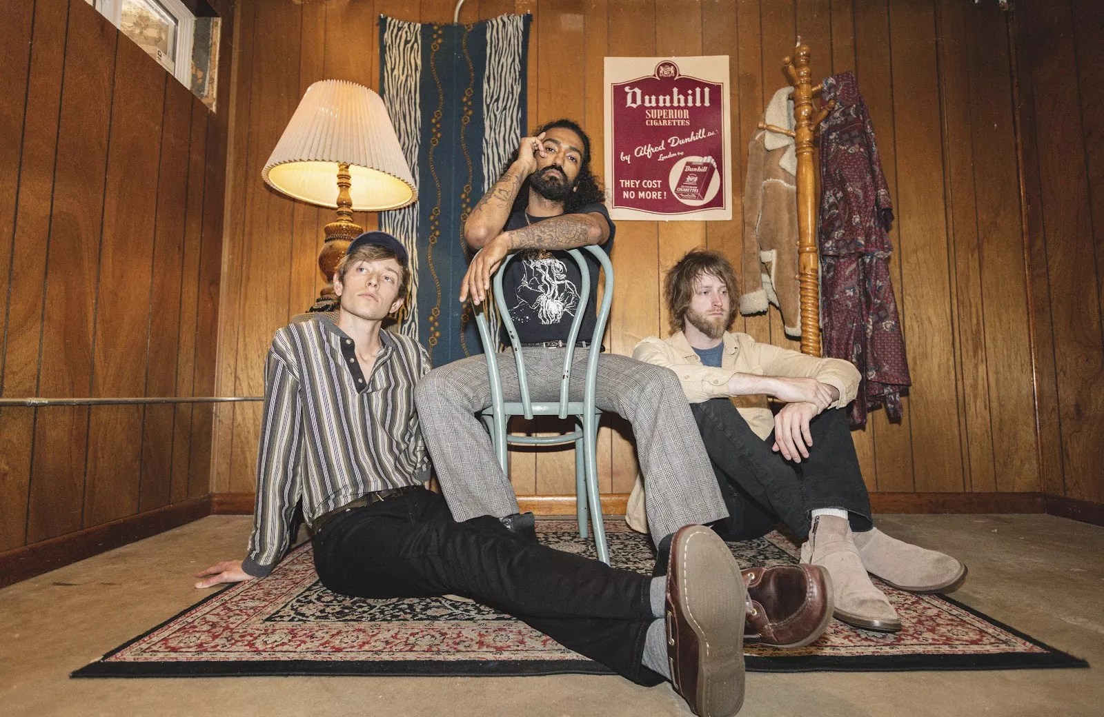 bandmates pose in a yellow room on vintage furniture
