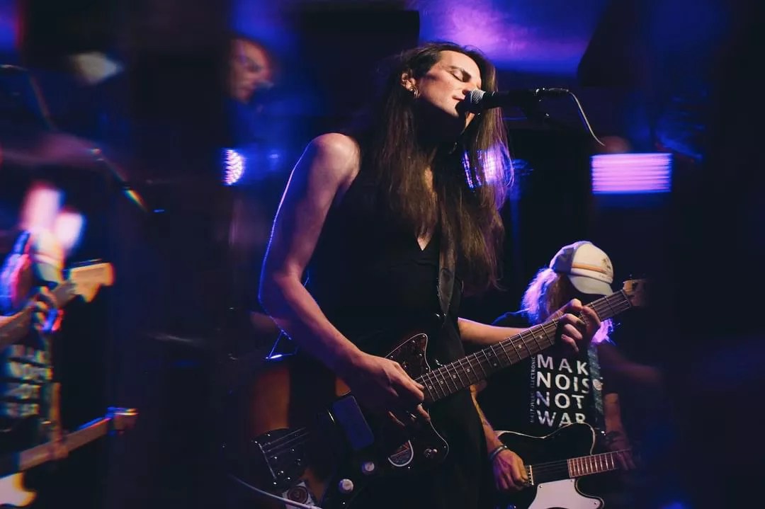 person singing into microphone while playing guitar