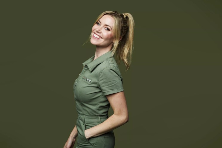 woman with blonde ponytail smiling in a green polo
