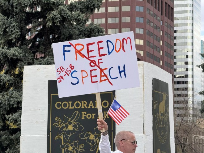 Man holds freedom of speech sign during protest at Colorado State Capitol