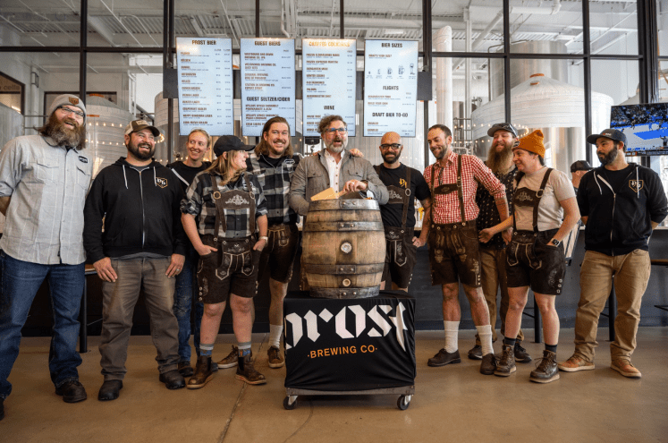 Group of people with a traditional barrel tapping.