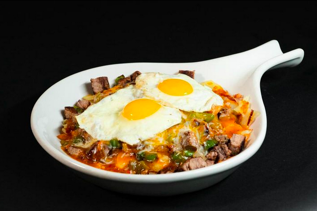 sunnyside up eggs over steak and potatoes