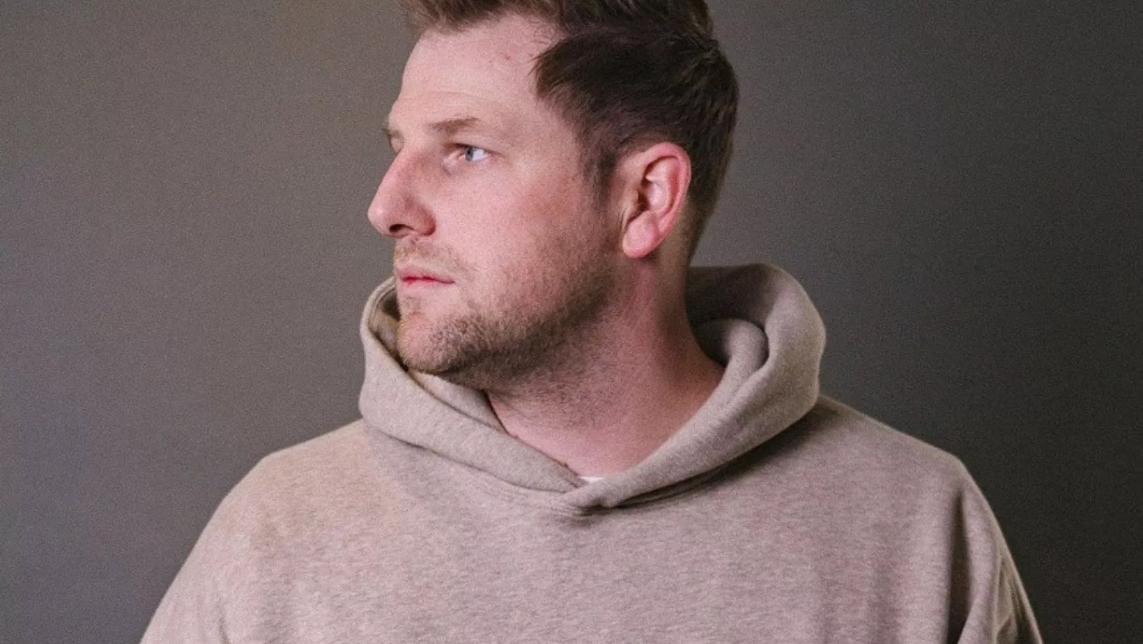 man in a tan sweatshirt