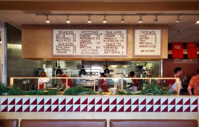view of a menu hanging over an ordering line inside a restaurant