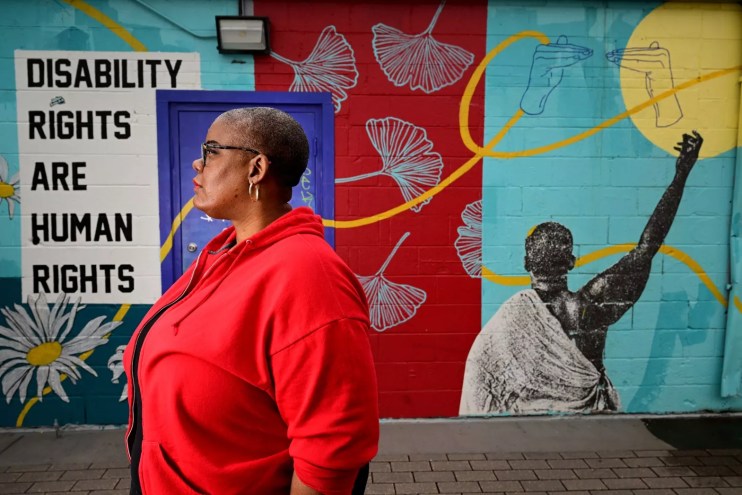 woman standing in front of an art installation