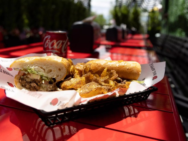 a sandwich and fries on a red table
