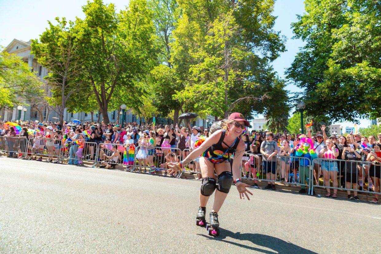 Woman roller blades down street during pride parade