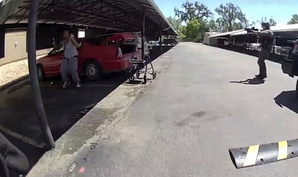 Kilyn Lewis seen on body cam video with his arms raised and a cell phone in his hand before being shot by an Aurora SWAT officer.