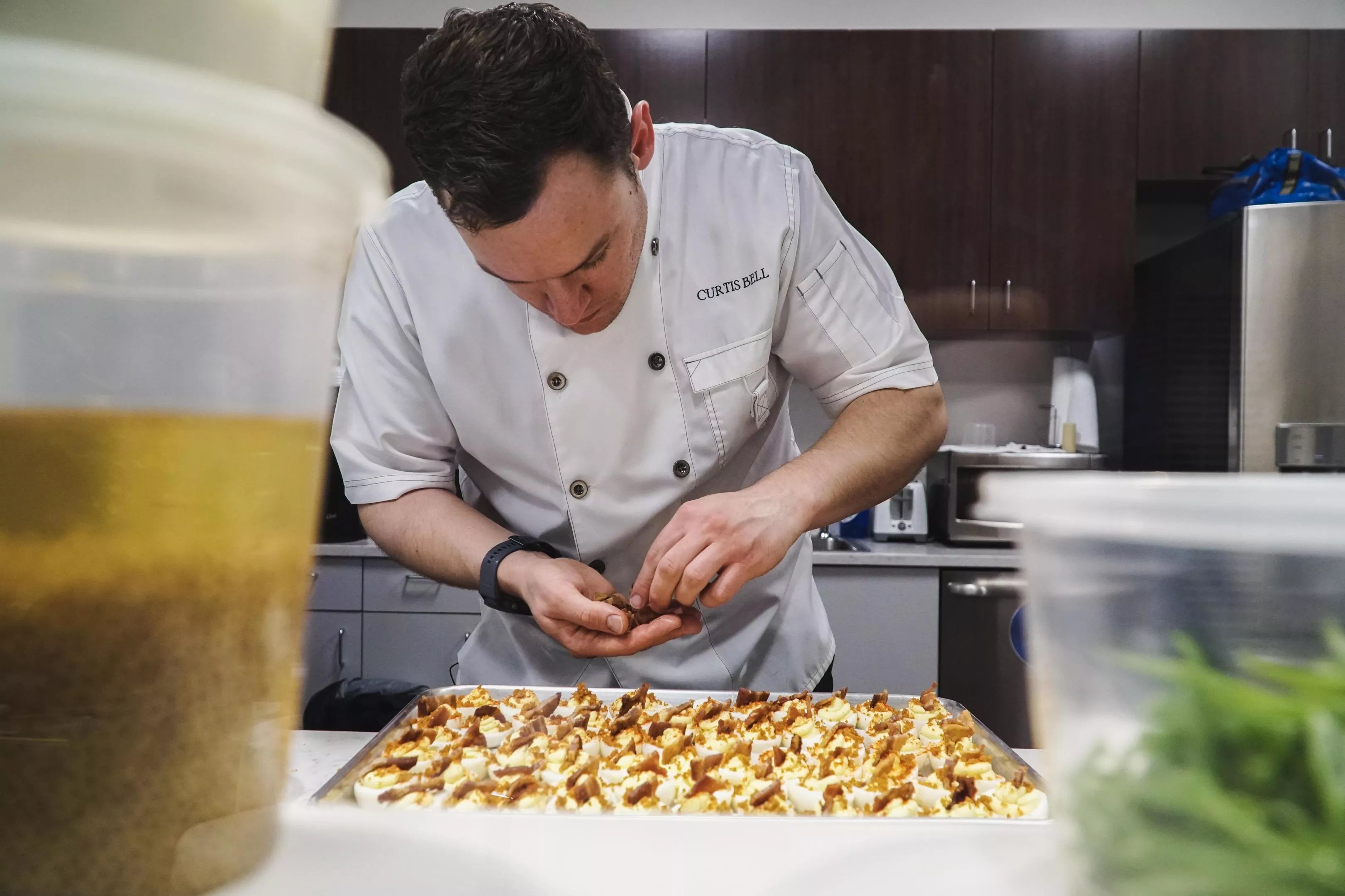 man in a chefs coat preparing food