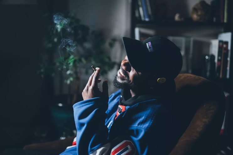 Man smokes joint in his home