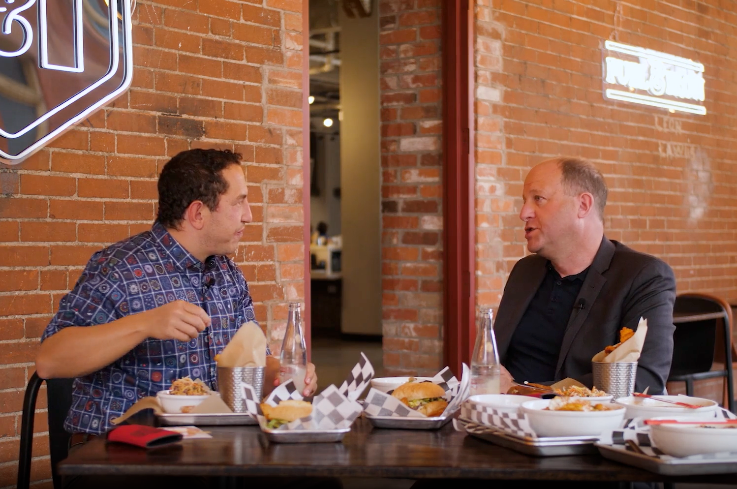 Governor Jared Polis and Alexander Heffner share a meal at Fuel & Iron in Pueblo.