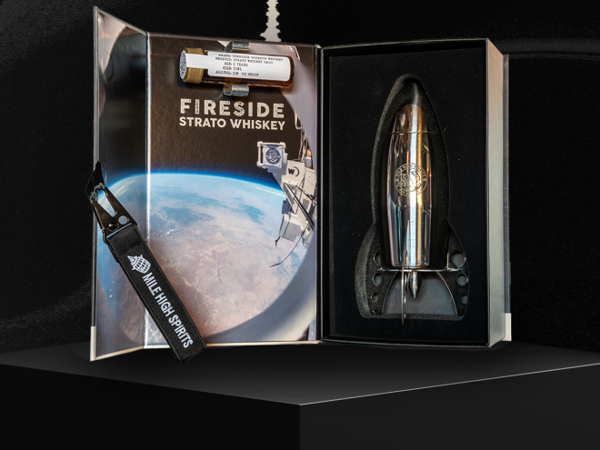 a rocket-shaped silver bottle in a box with a picture of the moon