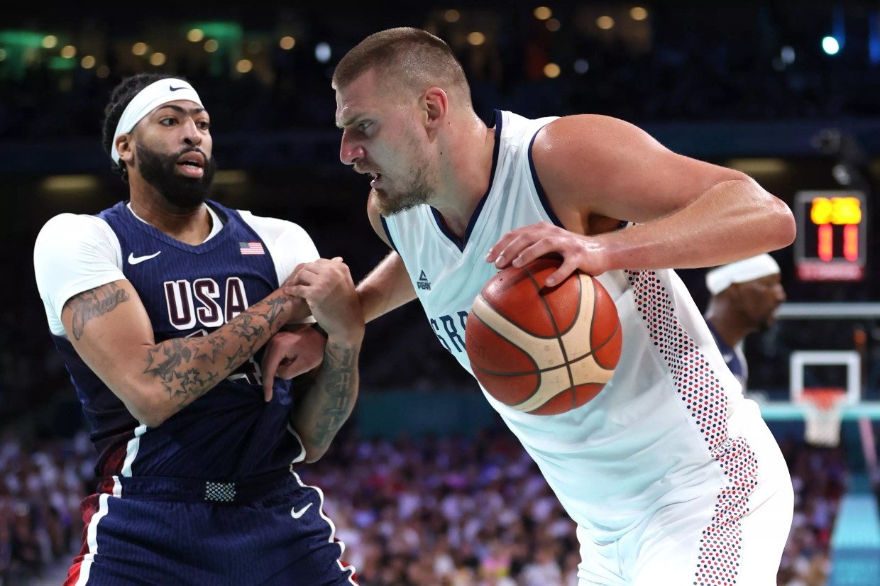 Nikola Jokic dribbles against Anthony Davis during an Olympic basketball game between the United States and Serbia