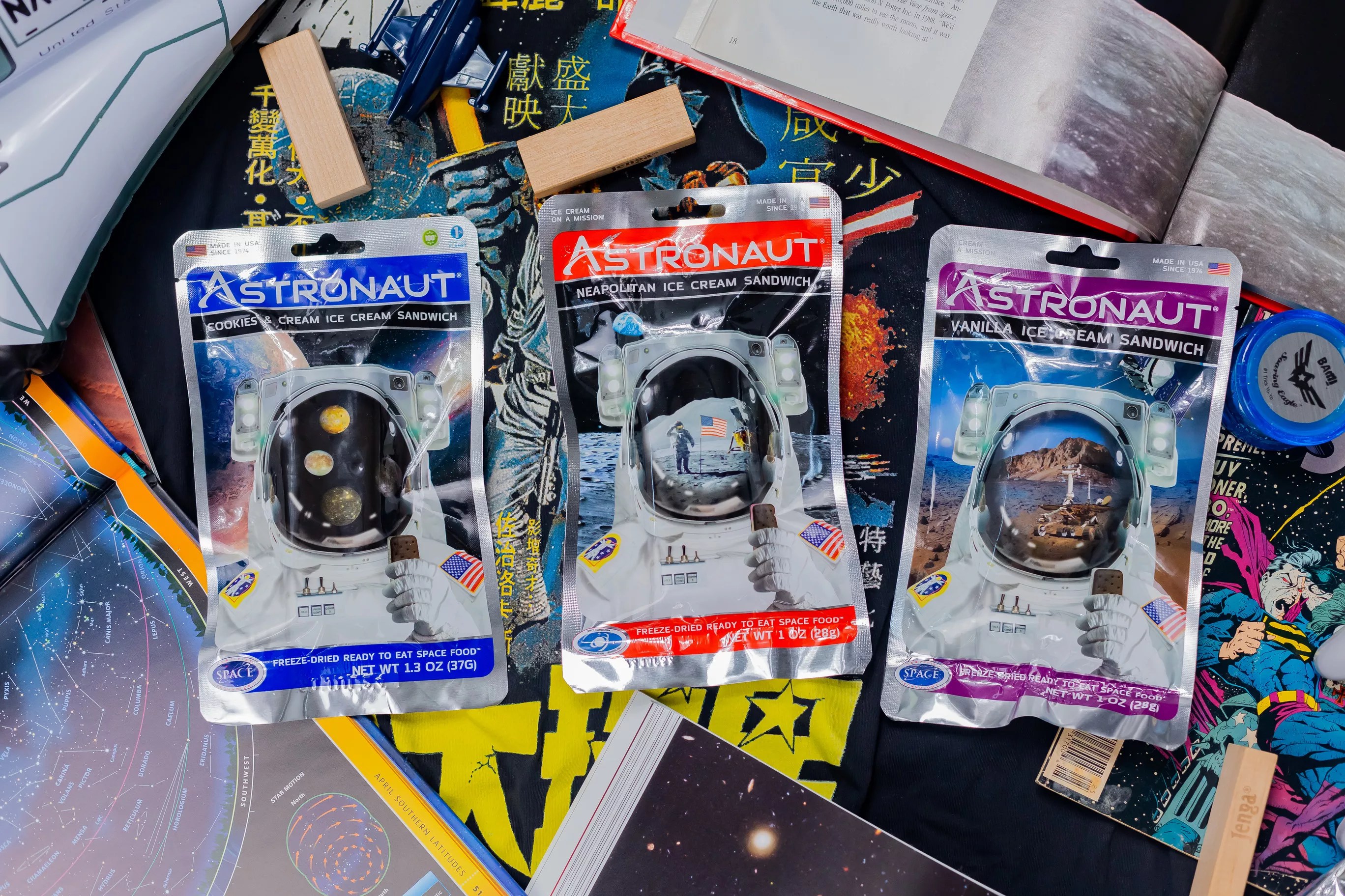Three Astronaut Foods ice cream sandwich packages backdropped by comic books