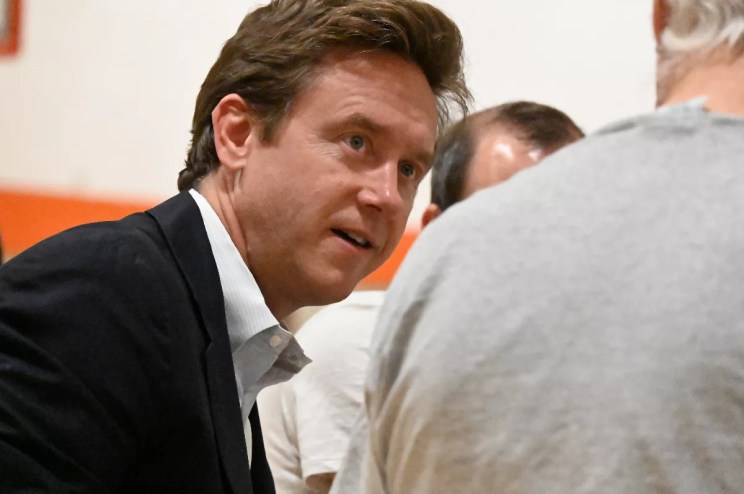 A man listens to another.