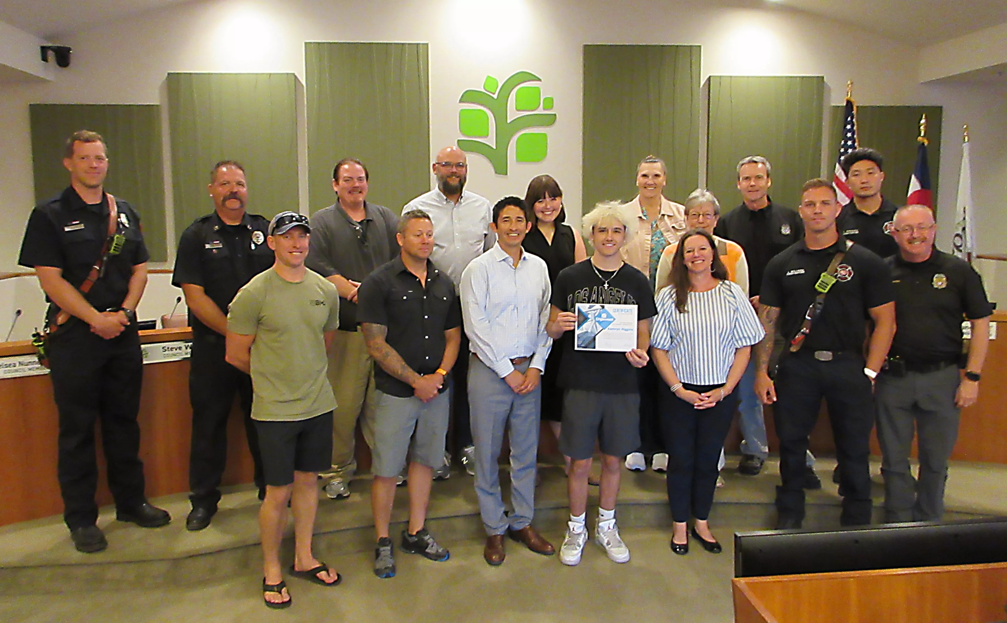 Teenager poses with city councilmembers, police and firefighters