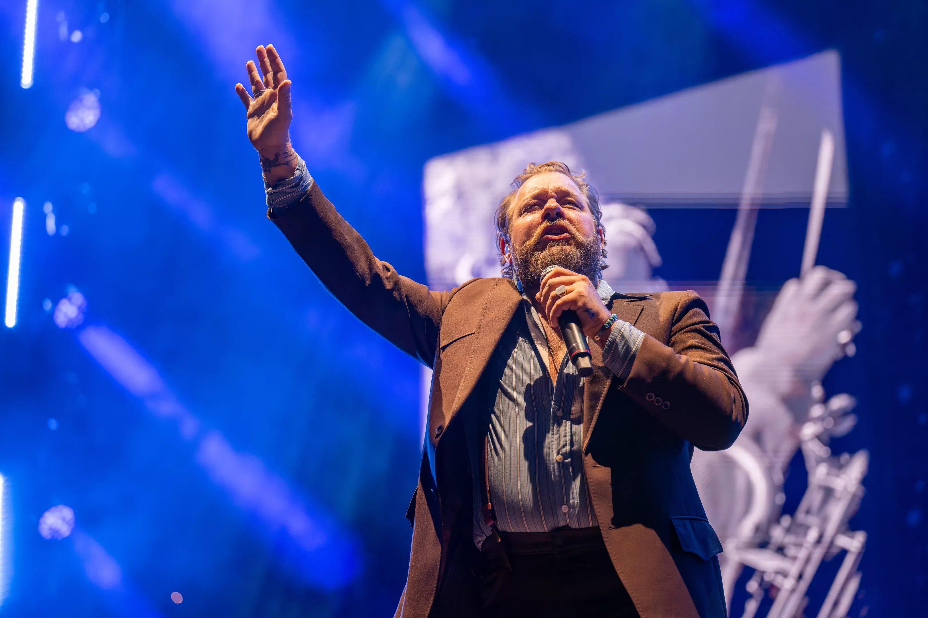 Man in brown jacket singing