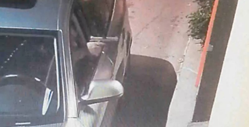 A man points a gun out of his car.