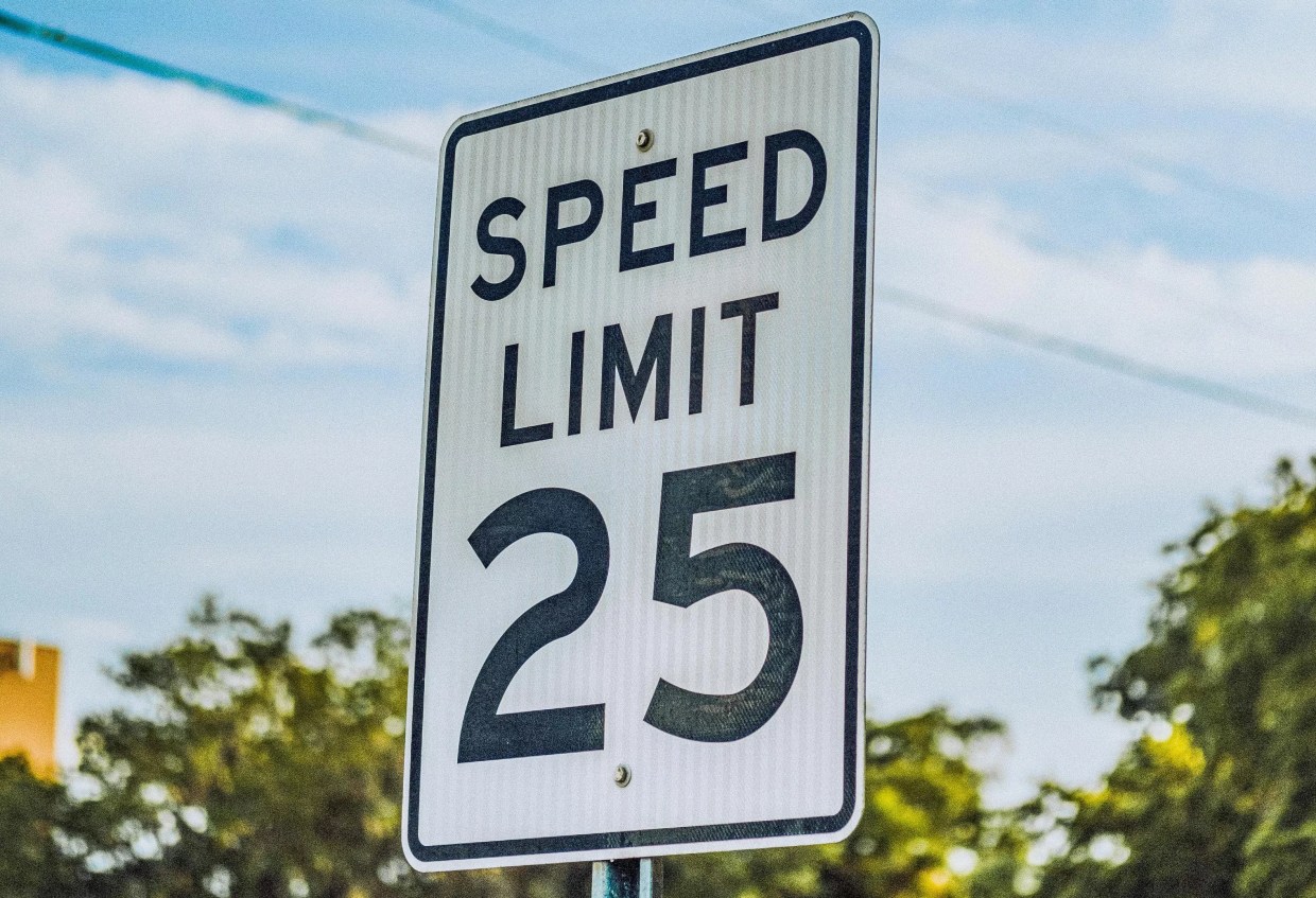 A 25 mph speed limit sign against a blue sky.
