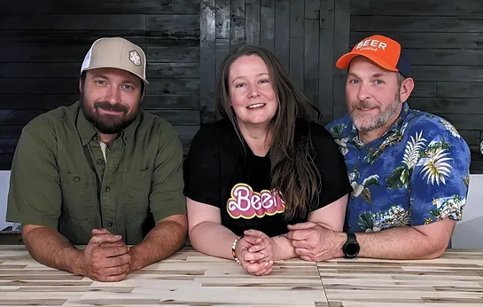 three people sitting and posing for a photo