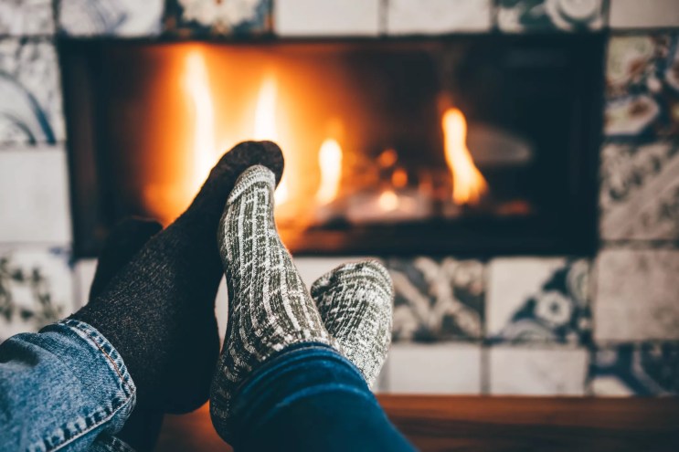 feet in socks in front of fireplace