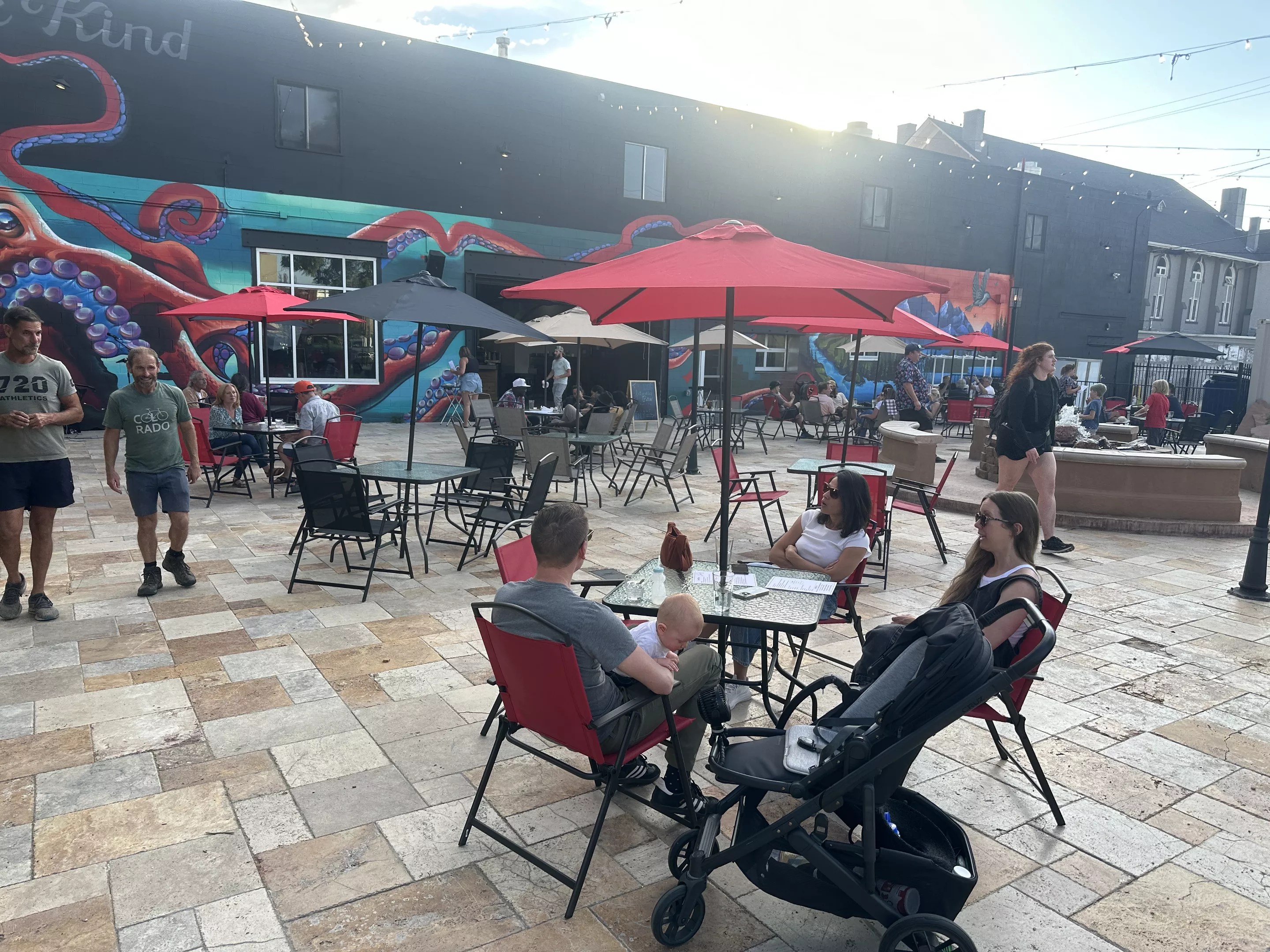 people sitting at tables on a patio