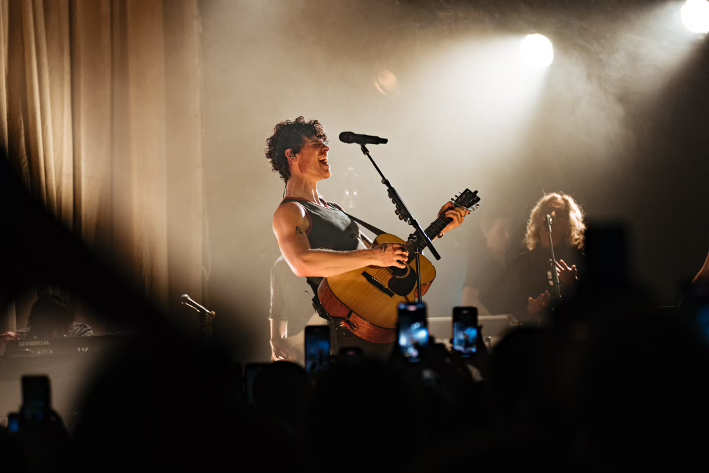 shawn mendes performing on stage with a guitar