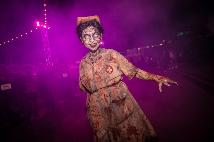 A 13th Floor Haunted House actor dressed in a blood-stained nurse costume