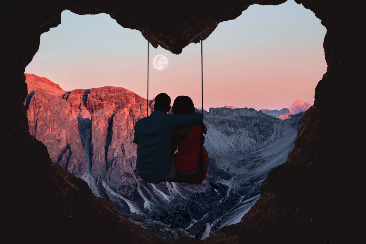 romantic couple on swing looking at mountains