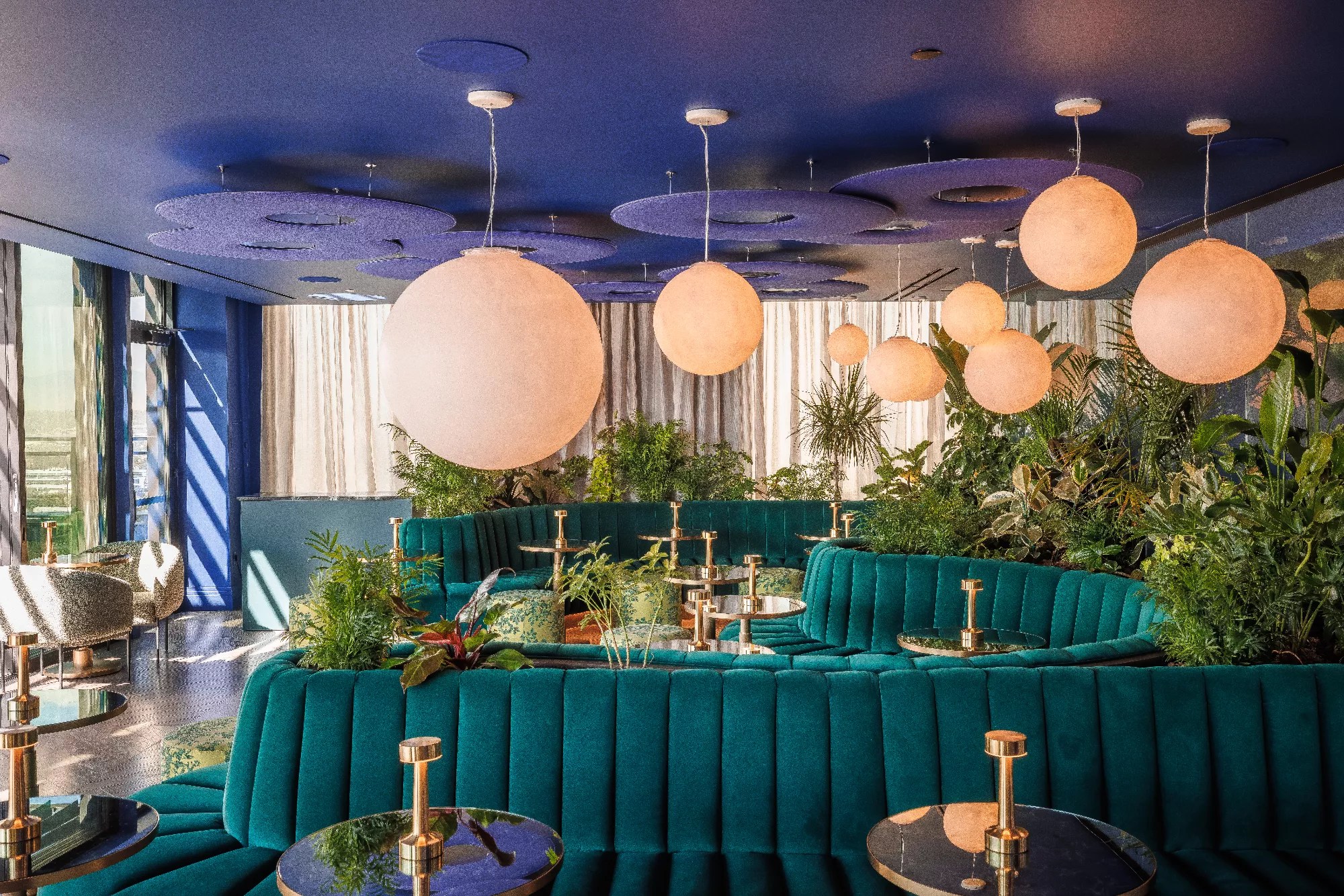 teal couches in a room with large round lights