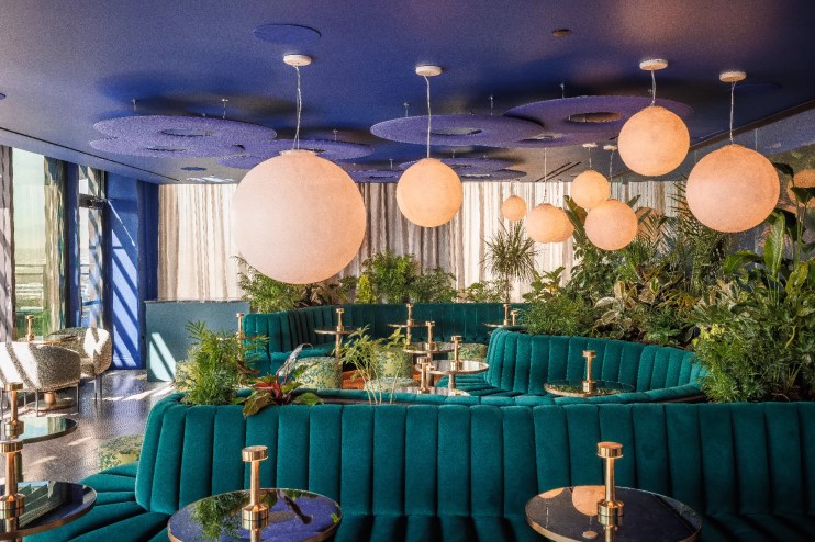 teal couches in a room with large round lights
