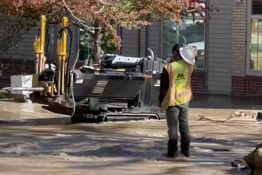 Man in reflective vest stands on street