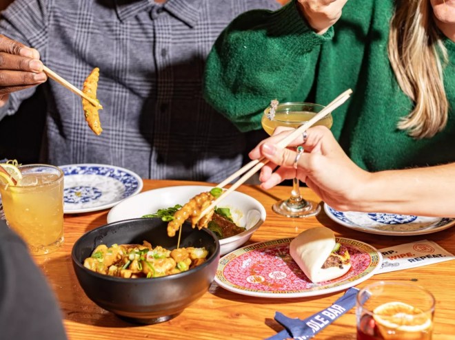 various food on plates being eaten with chopsticks