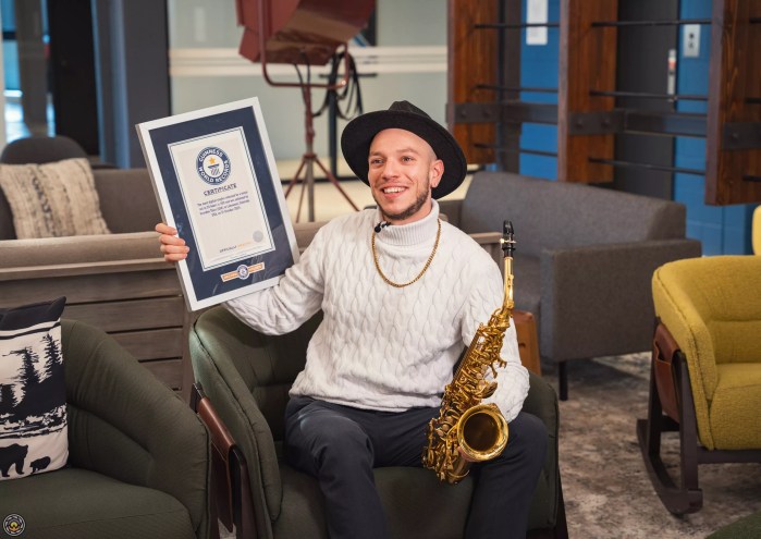 man with certificate and saxophone
