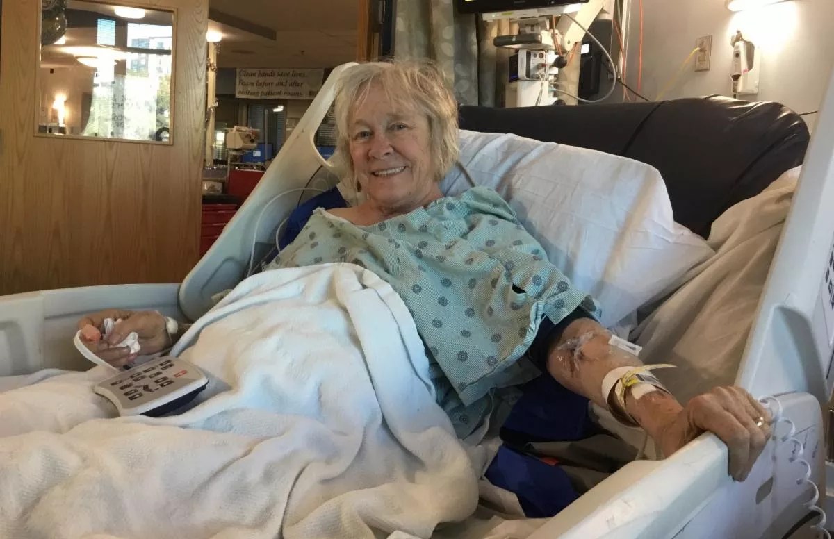A woman sits in a hospital bed.