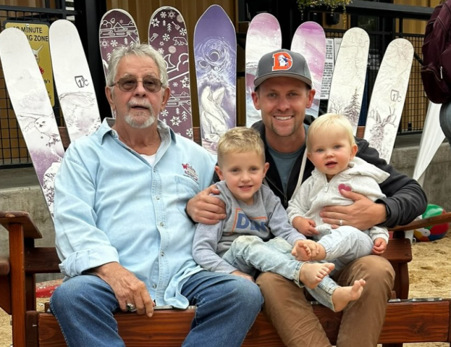 family sitting on a bench made of skis