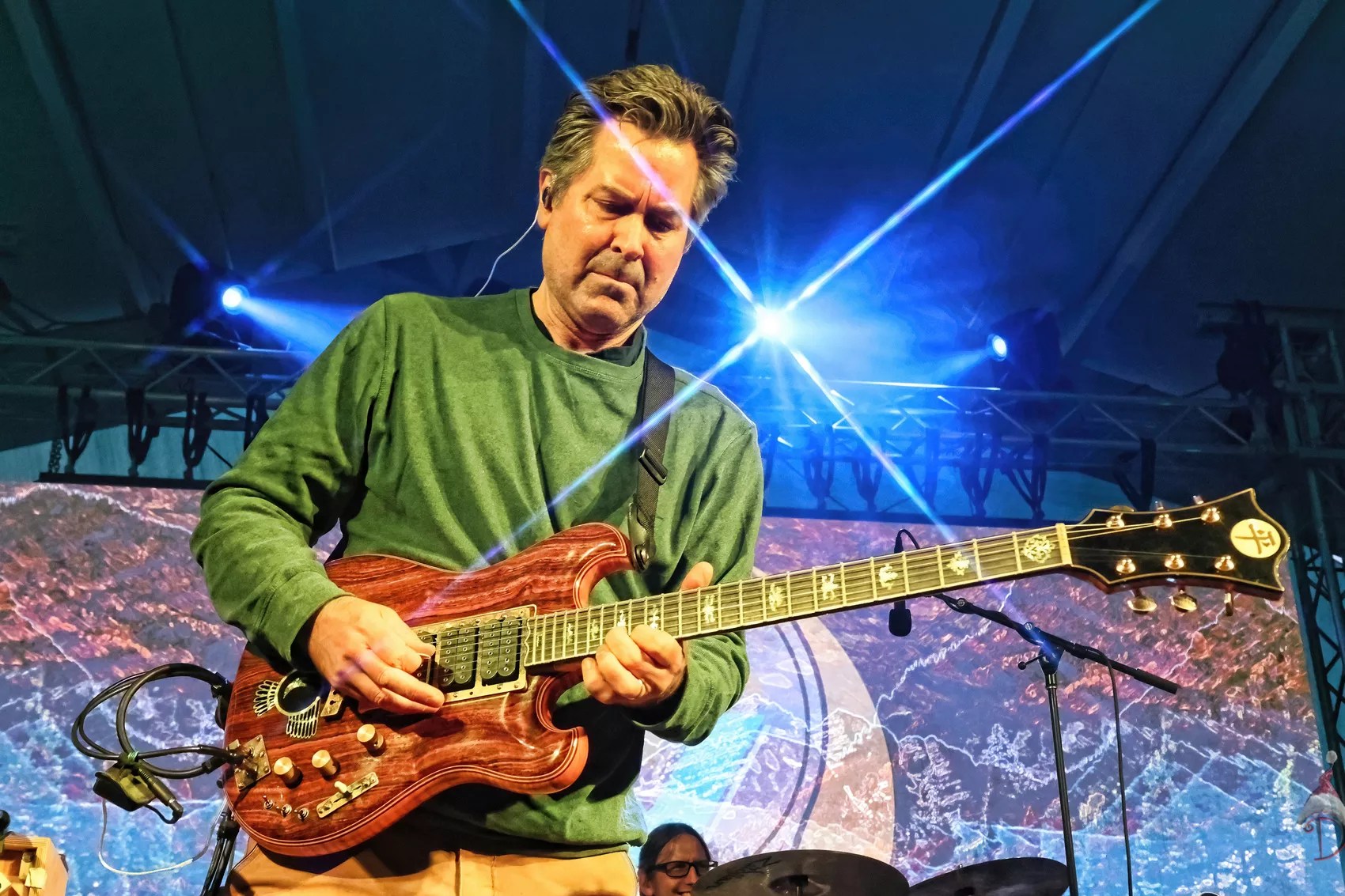 man playing guitar with lights in the background