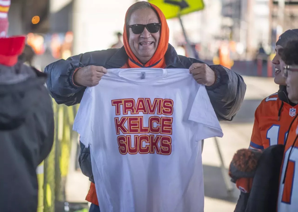 Denver Broncos fans holds Travis Kelce Sucks t shirt