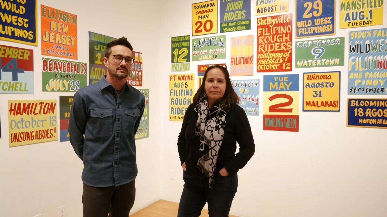 man and woman in front of gallery images