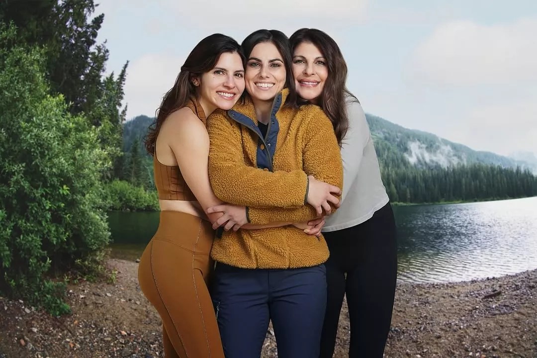 three women pose in outdoor clothing and smiling to camera