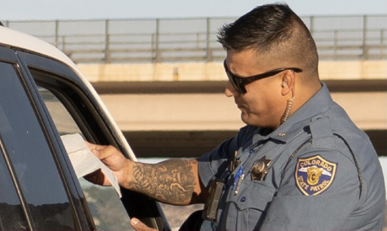 A police officer standing at a car door