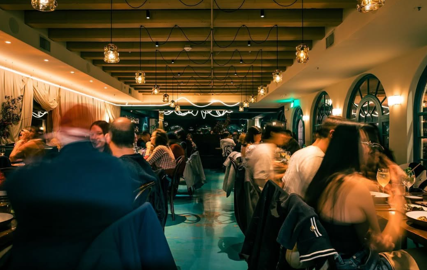 people sitting at tables inside a restaurant