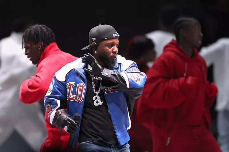 rapper in blue, with other performers in red