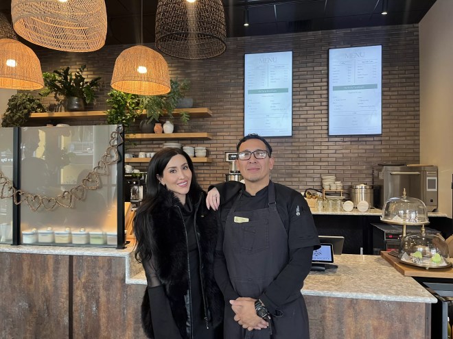 two people standing in a cafe